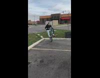 Guy does a wheelie over grass curb and falls backwards