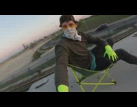 Guy sits green chair train roof bandana 