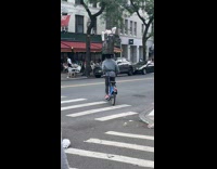 Collab WINY - Man on bike with garbage can on head  