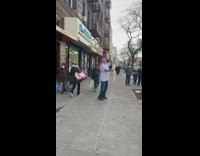 Guy tosses pizza dough outside on sidewalk 