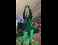 Woman takes a selfie with people dance behind her