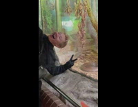 Man takes a selfie next to the snake in the glass