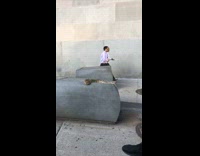 People walk by brown snake concrete block 