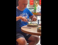 Man blue shirt slice pasta on plate