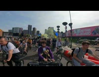 Guy riding a bike while carrying baby and turntables attached