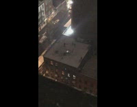 Group of friends play in snow on roof top