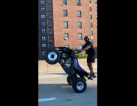 2 guys do wheelies on their ATV on freeway 