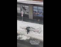 Person uses cutting board to shovel snow 