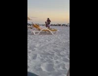Guy helps black bikini girl handstand beach 