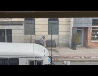 Woman in brown coat with a hat on the sidewalk