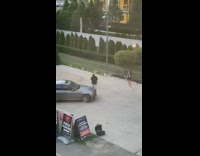 Man black shirt stands on  gray car joined by photographer
