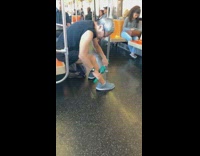 Man massages leg muscles with blue roller on subway train