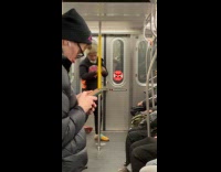 Man shadowbox the pole inside subway train