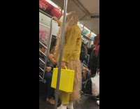 Woman with very long hair yellow jacket on subway train
