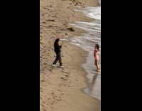 Woman in pink outfit poses at beach