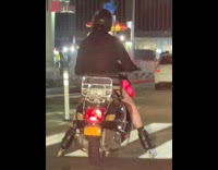 Guy wearing rollerblades rides motorcycle 