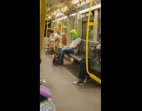 Guy on subway green bucket over head 