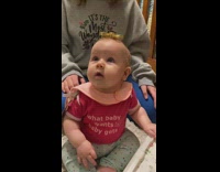 Girl trying to balance fidget spinner on baby