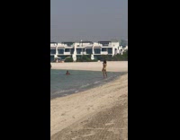 Woman pink bikini kick and fall beach