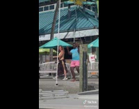 Guy in blue shirt dances on boardwalk 