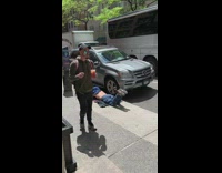 Man lay on his stomach with shirt off on the sidewalk