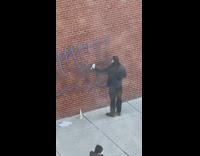 Guy scrubs graffiti off wall toilet brush 