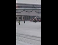 Baggage handlers snowball fight during a snowstorm