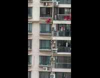 Guy rope around waist hangs outside window 