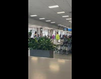 Man in neon jacket walks towards the airport exit