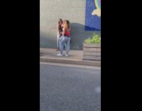 Two girls grey brick wall, rainbow mural