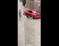 red car black shirt guy wood fence