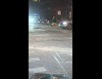 Man in elf costume hops through crosswalk