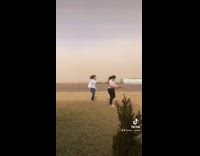 Two girls walking across yard holding pizza box 