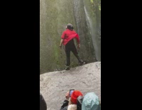 Man poses like superman red polo moves waterfalls