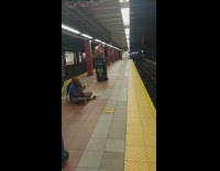 Guy sits on trash can no shoes 
