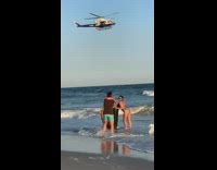 Two girls pose beach shore NYPD helicopter 