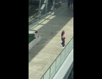 Young boy take sister photo glass railings