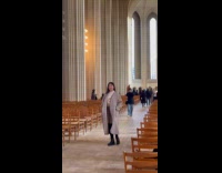 Woman gray coat poses inside the cathedral
