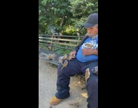 Man at park feeds birds and squirrel 