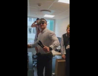 Guy throws raw hotdogs onto grill two guys dancing behind him