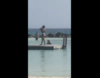 Woman stands on platform in beach and takes pictures