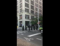 Group of people in black robes crossing the crosswalk in the day 
