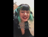 Girl black blue hair mouthing words in bathroom