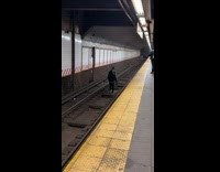 Guy walks down on the train rails 
