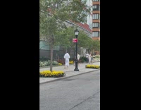 Guy wearing robe walks barefoot outside 