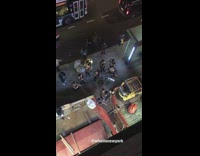 Live band with drums, tuba, and trumpets plays music in front of subway station