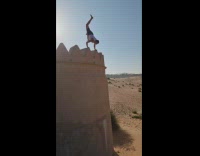Guy falls on sand after handstand 