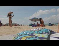 Girl striped bikini kneel peace sign beach
