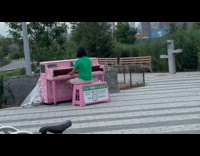 Man green shirt play pink piano park