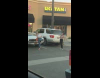 Girl holding orange container poses by car